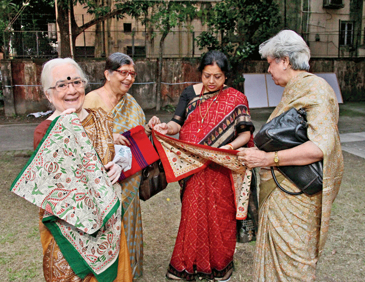 Monjula Datta, vice-president of Nari Seva Sangha, displays a kantha product as Debjani Sengupta, secretary, and committee members Achina Bhattacharya Kundu and Tapati Guha look on