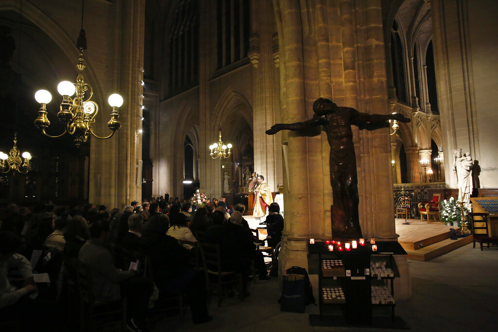 Believers the Christmas mass, in Saint-Germain l'Auxerrois church, in Paris, Tuesday, Dec. 24, 2019. Notre Dame Cathedral is unable to host Christmas services for the first time since the French Revolution, because the Paris landmark was too deeply damaged by this year's fire.