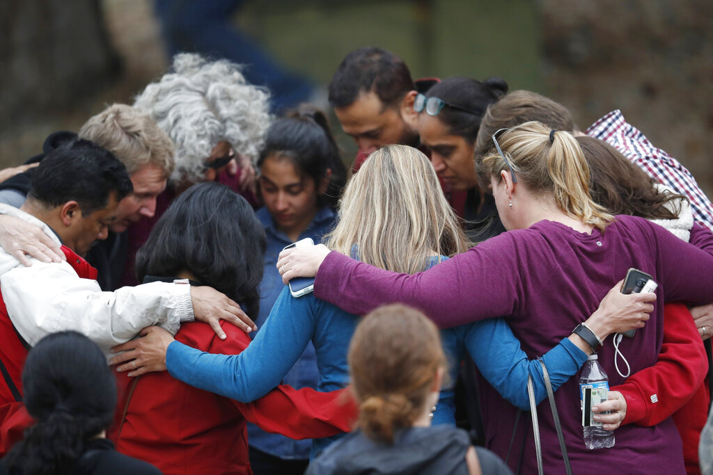 Parents gather in a circle to pray at a recreation centre where students were reunited with their parents after the shooting.