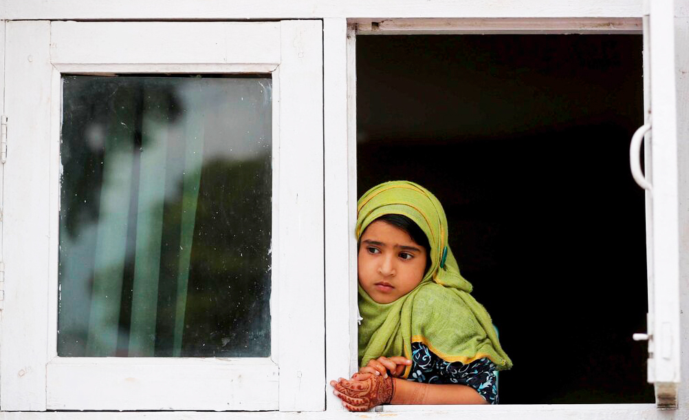 In this Friday, August 30, 2019, file photo, a child watches a protest from the window of a shrine in Srinagar.
