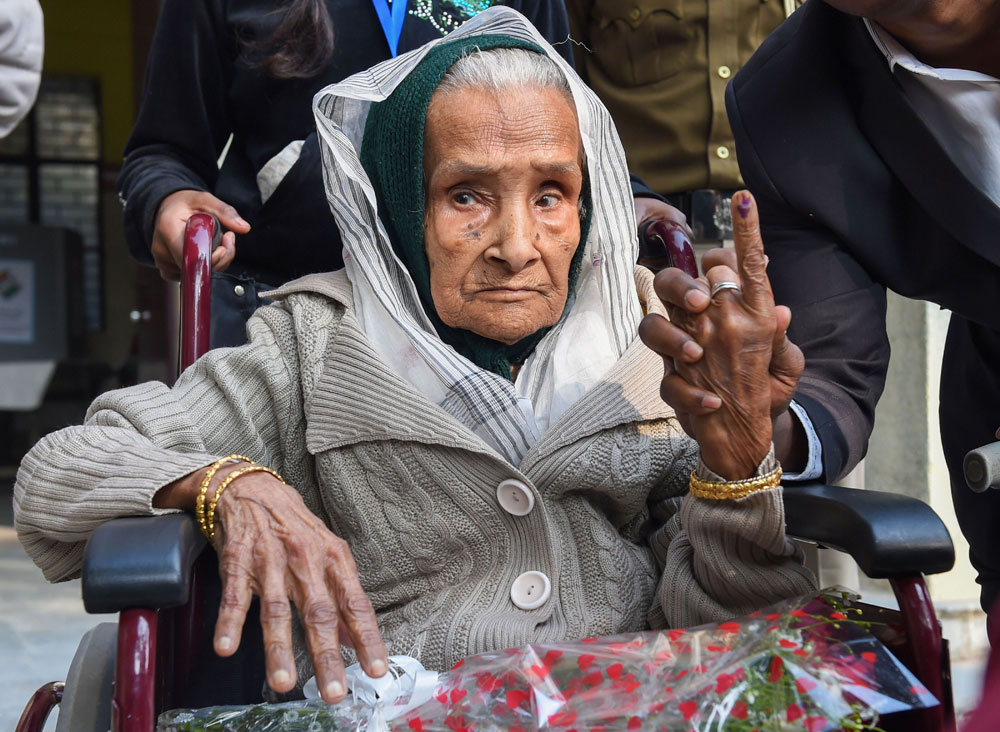 111-year-old Kalitara Mandal shows her finger marked with indelible ink after casting vote during the Delhi Assembly elections at Chittaranjan Park polling station, in New Delhi