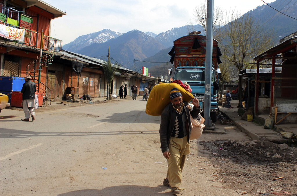 A Pakistani Kashmiri walks through a market at his hometown in Chakoti on the India-Pakistan border.
