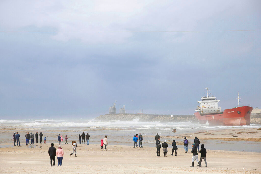 People look at the Zelek Star cargo ship carrying cement, stranded in the Mediterranean Sea beach in the southern Israeli port city of Ashdod, on Friday.