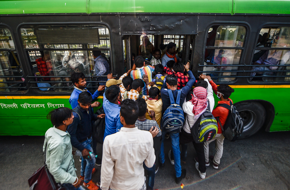 Passengers board a bus in New Delhi on Monday