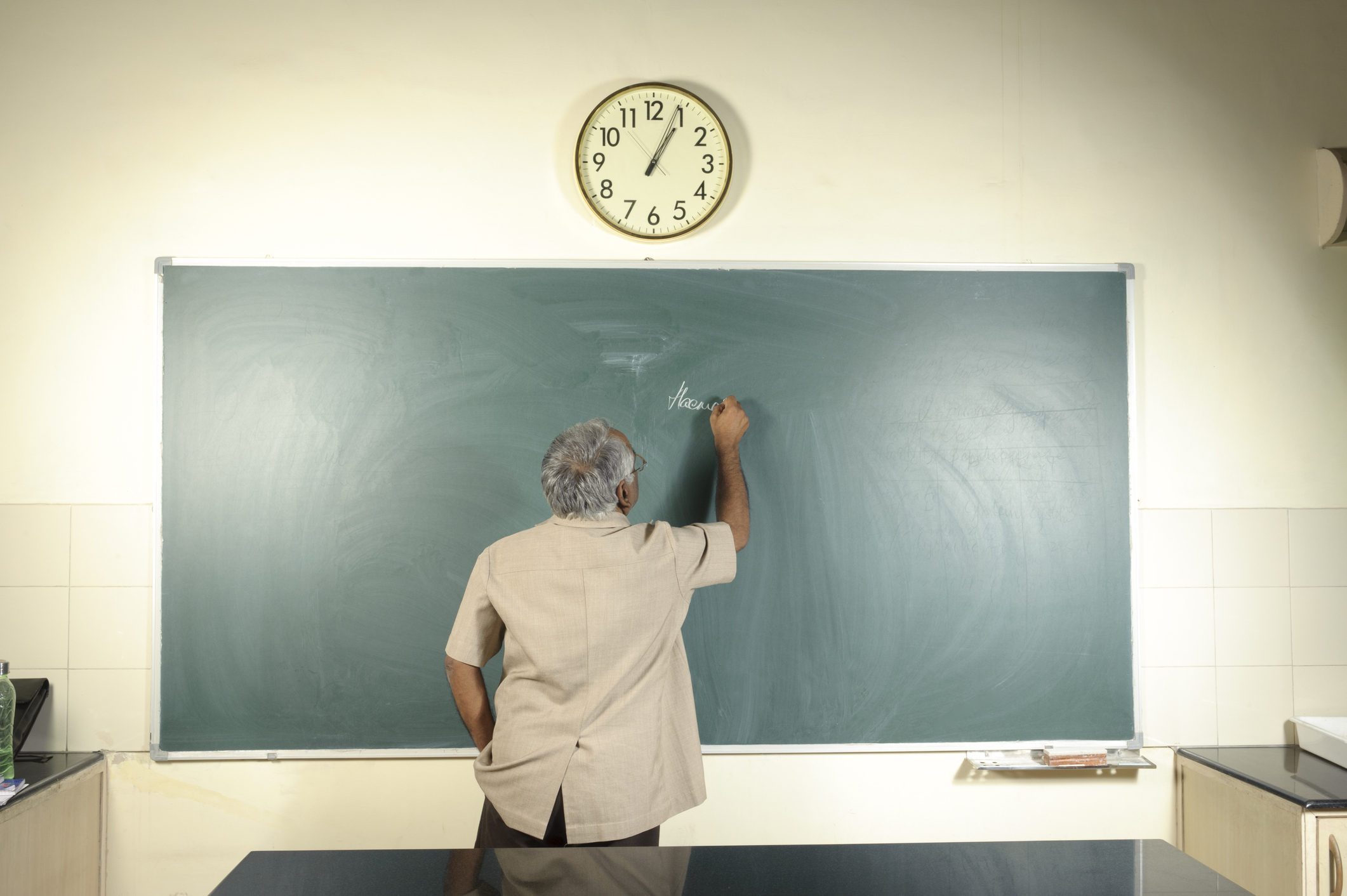 The teacher late. Pictures on the blackboard. Professor writing to the desktop.