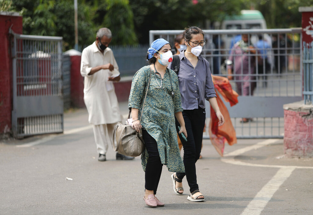 Doctors wearing masks walk outside a hospital in Jammu, India, Tuesday, June 23, 2020.
