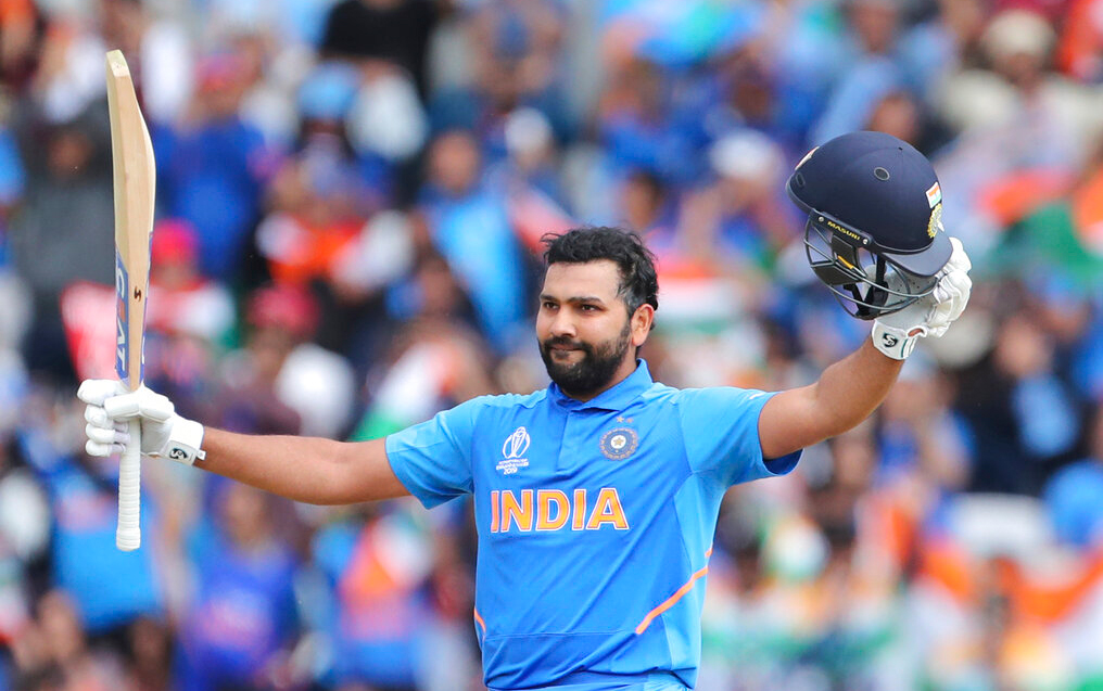 Rohit Sharma raises his bat and helmet to celebrate a century during the Cricket World Cup match between India and Sri Lanka at Headingley in Leeds, England, Saturday, July 6, 2019. 