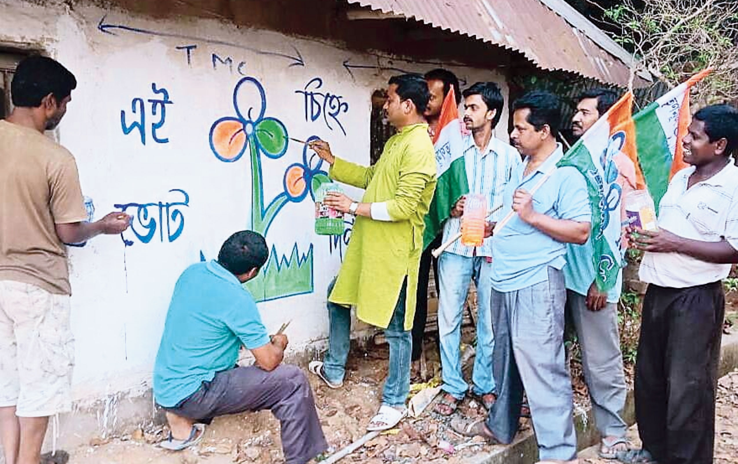 Trinamul members painting their party symbol on a wall in Midnapore.