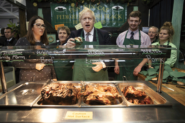 Boris Johnson greets customers on a stall selling meat sandwiches at the Welsh County Show in Llanelwedd, Wales, Monday November 25, 2019