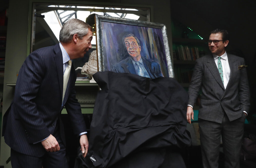 Brexit Party leader Nigel Farage, left, unveils a portrait of himself with the artist Dan Llywelyn Hall at right, in London, on Thursday. The painting is to be sold in aid of a charity that looks after military veterans.