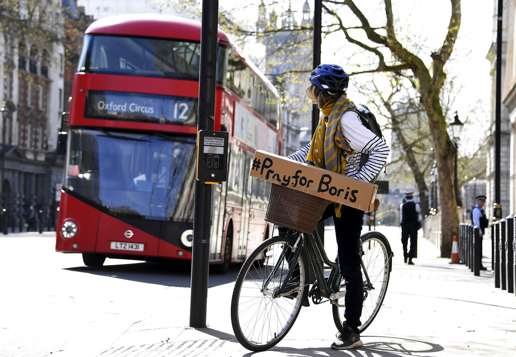 A woman shows a sign on her bicycle as British Prime Minister Boris Johnson is in intensive care fighting the coronavirus in London, Tuesday, April 7, 2020. 
