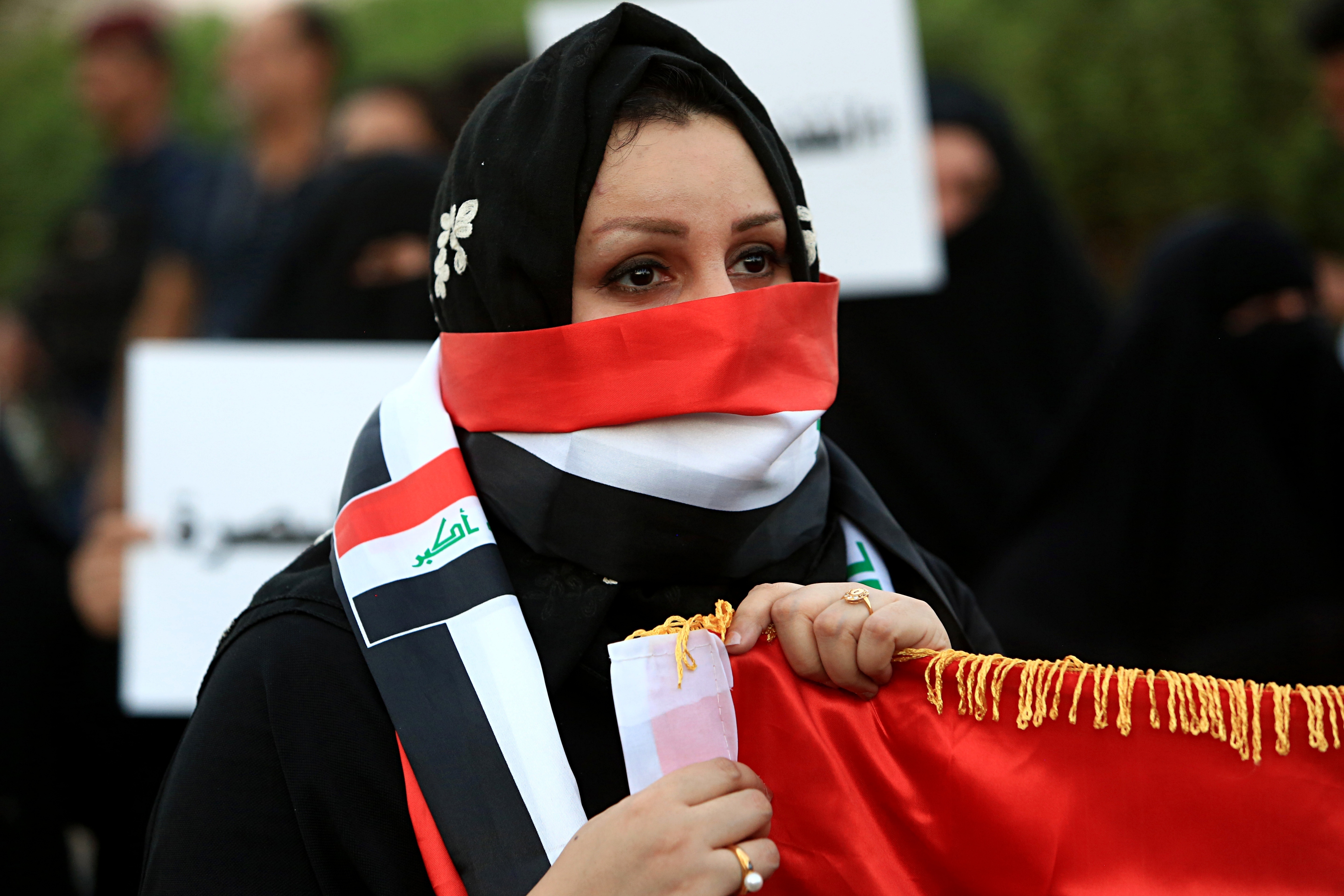 In this September 25, 2018, file photo, an Iraqi activist covers her face to hide her identity during a protest in Basra, Iraq.