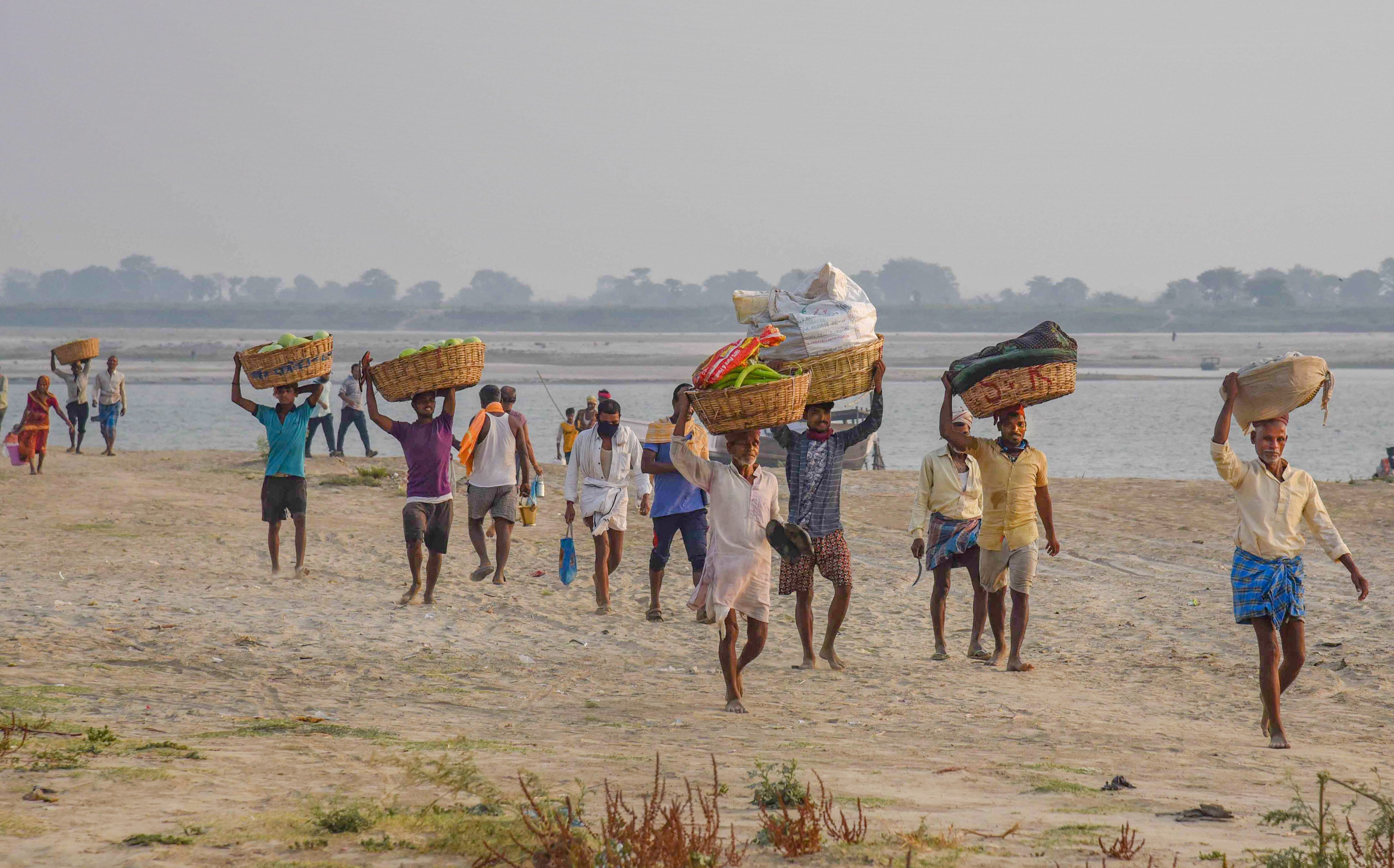 Farmers carry vegetables to a wholesale market for sale during the nationwide lockdown to curb the spread of coronavirus, in Patna, Thursday, April 16, 2020