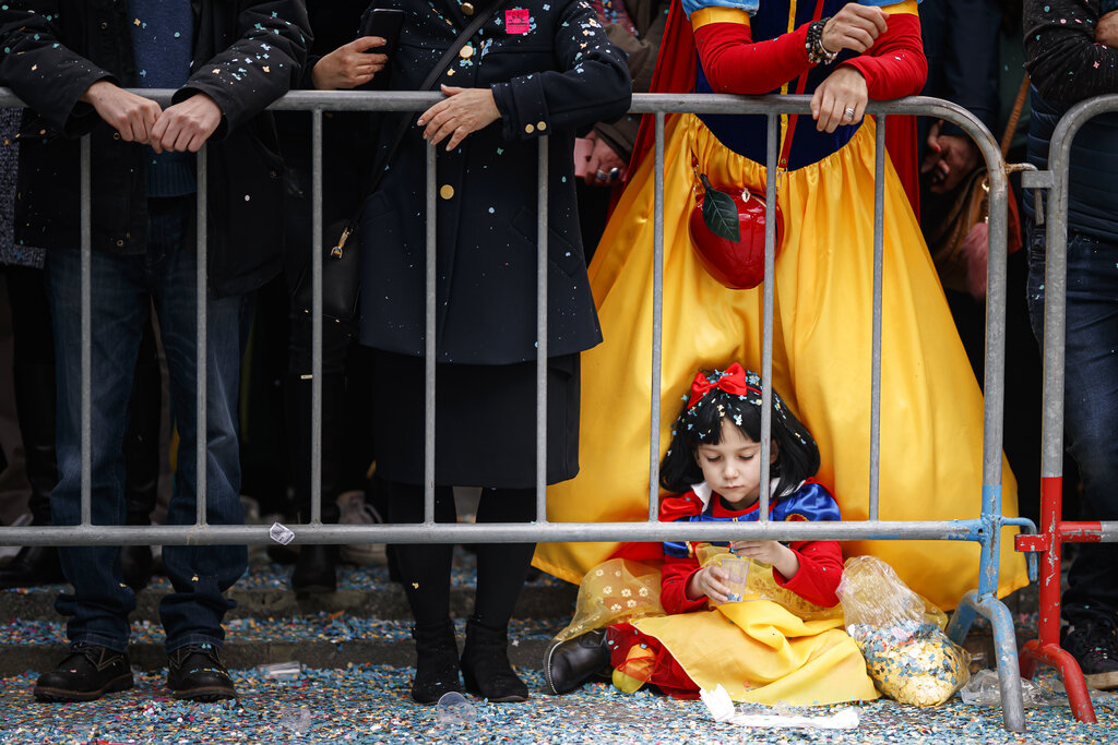 A young girl dressed as Snow White plays with confetti as she waits for the main parade of the 148th Monthey Carnival in Monthey, Switzerland