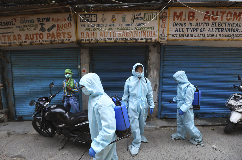 Heath workers spray disinfectants at an auto spares market anticipating a partial reopening during the nationwide lockdown in New Delhi, Monday, May 18, 2020.