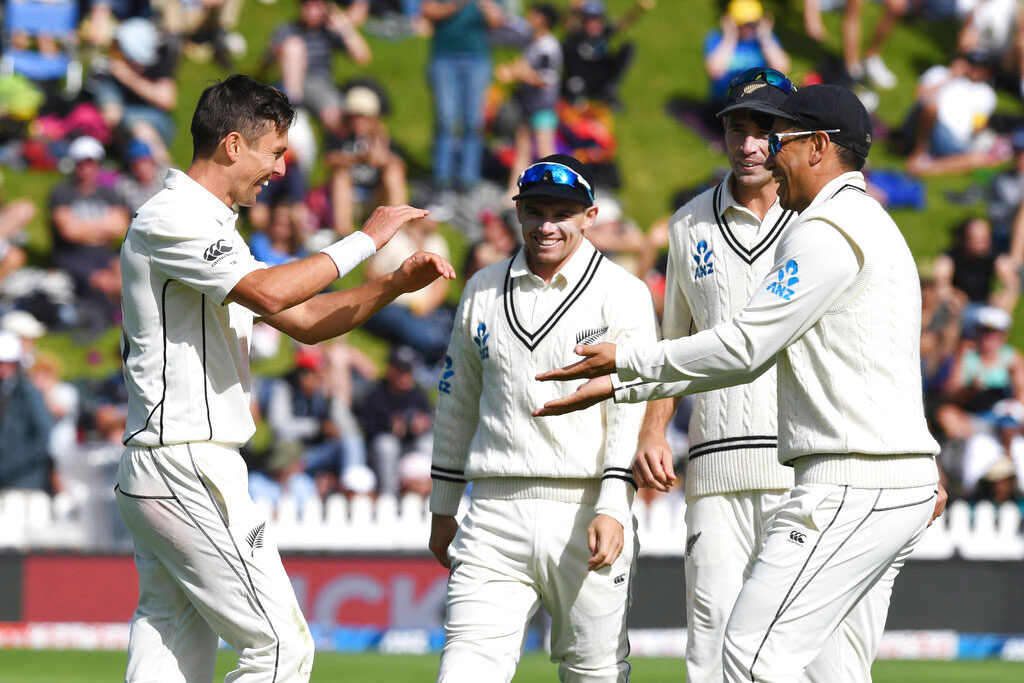 Trent Boult (left) celebrates with teammate Ross Taylor the bowling India's Cheteshwar Pujara for 11 during the first cricket test between India and New Zealand in Wellington on Sunday