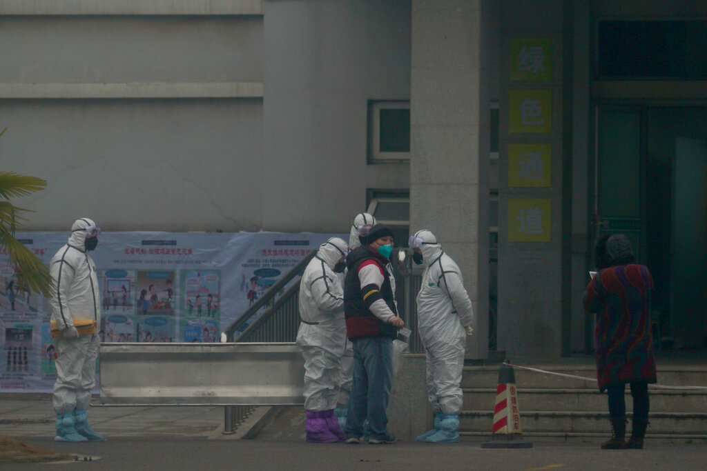 Staff in biohazard suits hold a metal stretcher by the in-patient department of Wuhan Medical Treatment Center, where some infected with a novel coronavirus are being treated, in Wuhan, China, on January 21, 2020. 