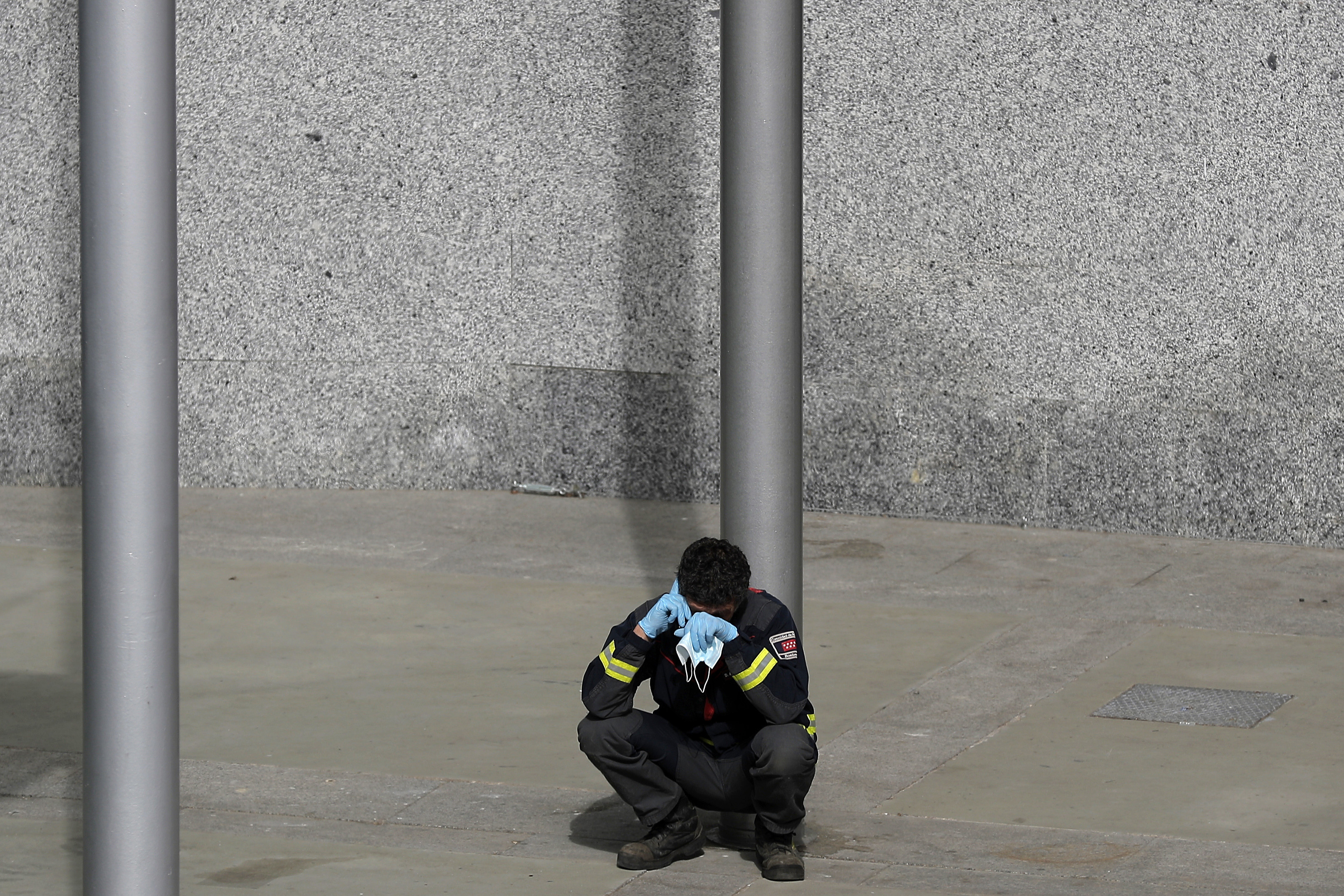 A firefighter talks on his phone as he rests at a temporary field hospital set in Ifema convention and exhibition in Madrid, Spain