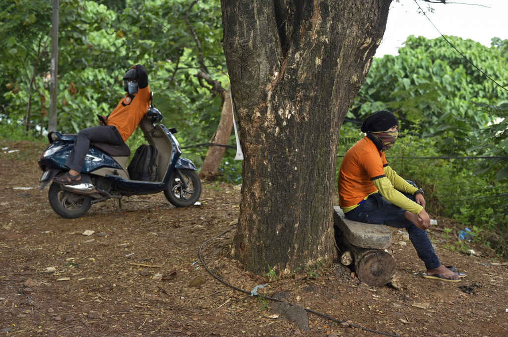 Food delivery personnel take rest under the shade of a tree as they await their next order during lockdown to contain the spread of coronavirus in Kochi, Sunday, May 17, 2020.