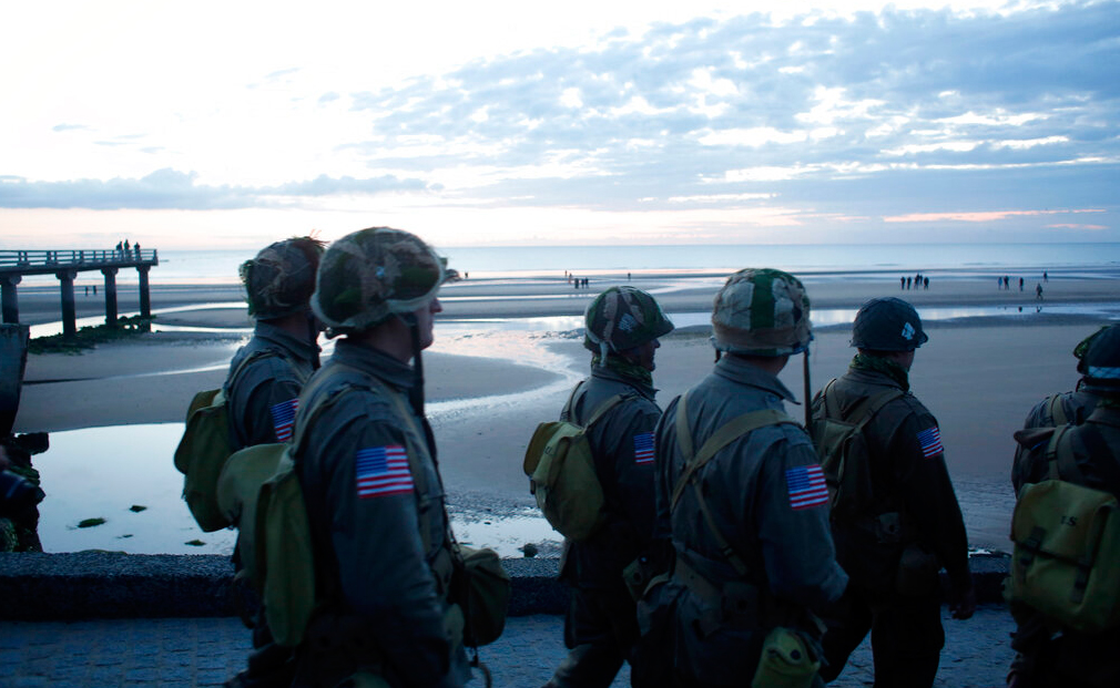 World War II re-enactors walk down to Omaha Beach, in Normandy, France, at dawn on Thursday, June 6, 2019 during commemorations of the 75th anniversary of D-Day.