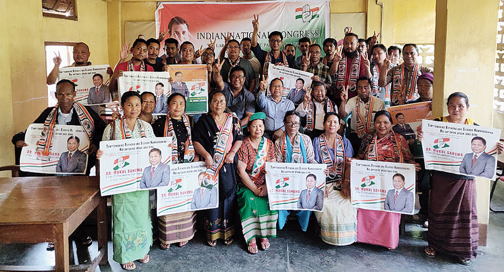 Congress supporters hold posters of Mukul Sangma in Tura