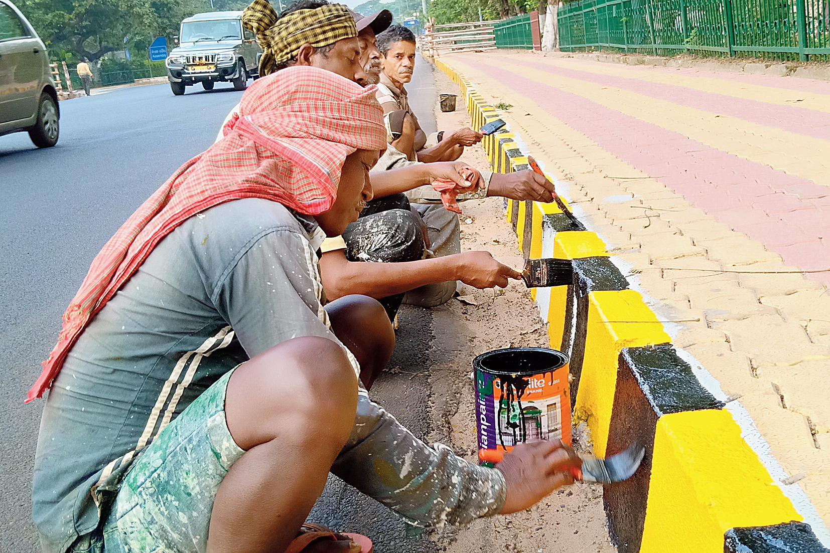 Labourers paint a median on a road to ensure road safety during the upcoming Hockey World Cup in Bhubaneswar on Friday. 
