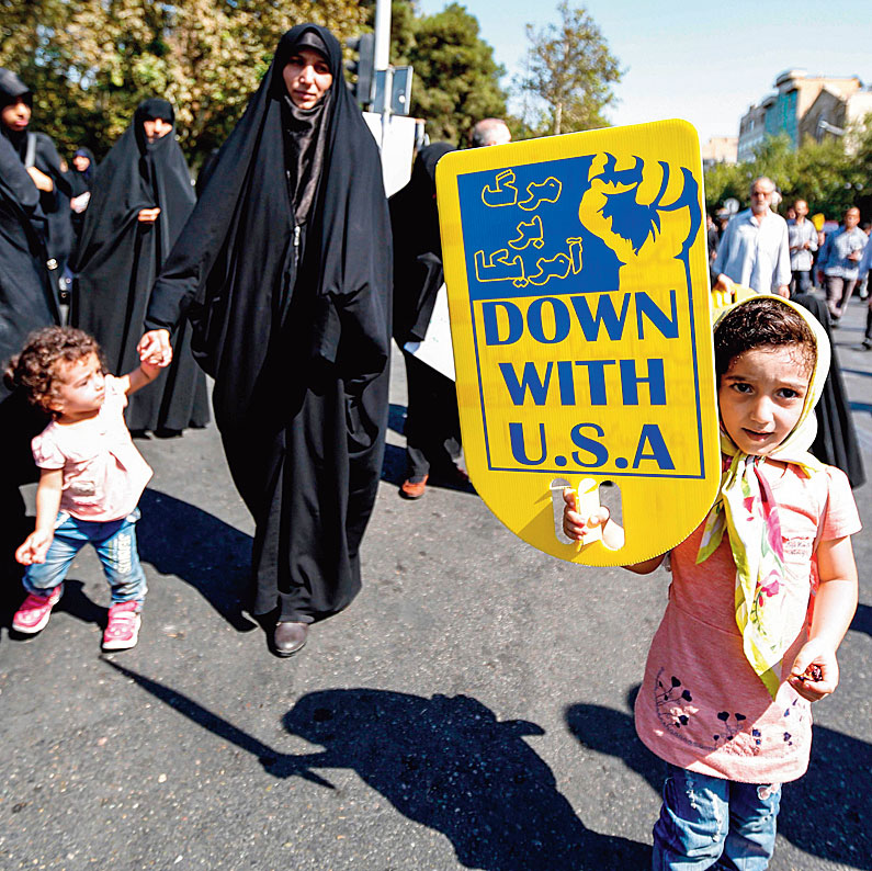 An Iranian girl raises an anti-US sign as she marches in a demonstration. 