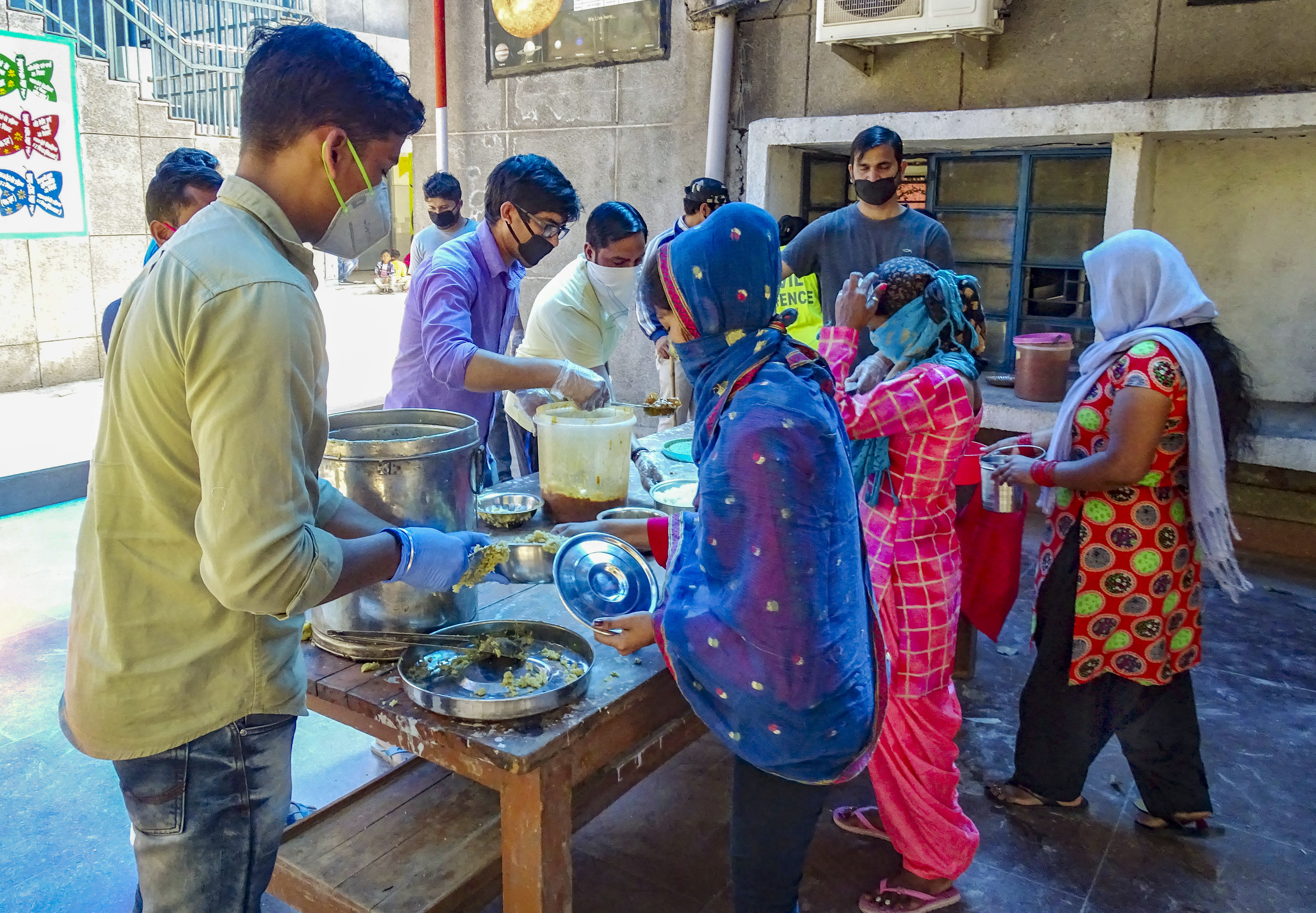 Delhi government workers distribute food during a nationwide lockdown, imposed in the wake of coronavirus pandemic, at a school in Patparganj, East Delhi, Sunday, March 29, 2020