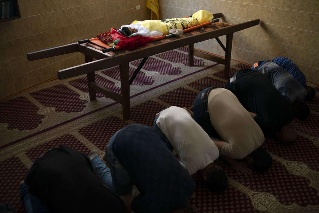 Palestinians pray next to the body of 11-year-old Shady Abdel-al at his funeral in Beit Lahiya, northern Gaza Strip. Though the health ministry initially reported Abdel-al was shot by Israeli fire, the Israeli army claimed he was accidentally struck by a rock thrown by protesters.