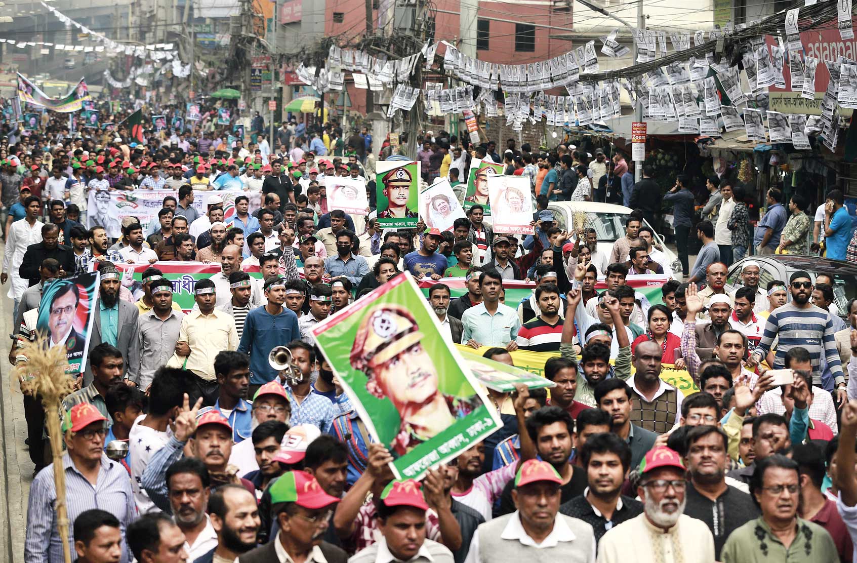 Bangladesh’s Jatiya Oikya Front supporters display pictures of former President Ziaur Rahman and former Prime Minister Khaleda Zia as they march in a rally to mark Victory Day in Dhaka on Sunday. 
