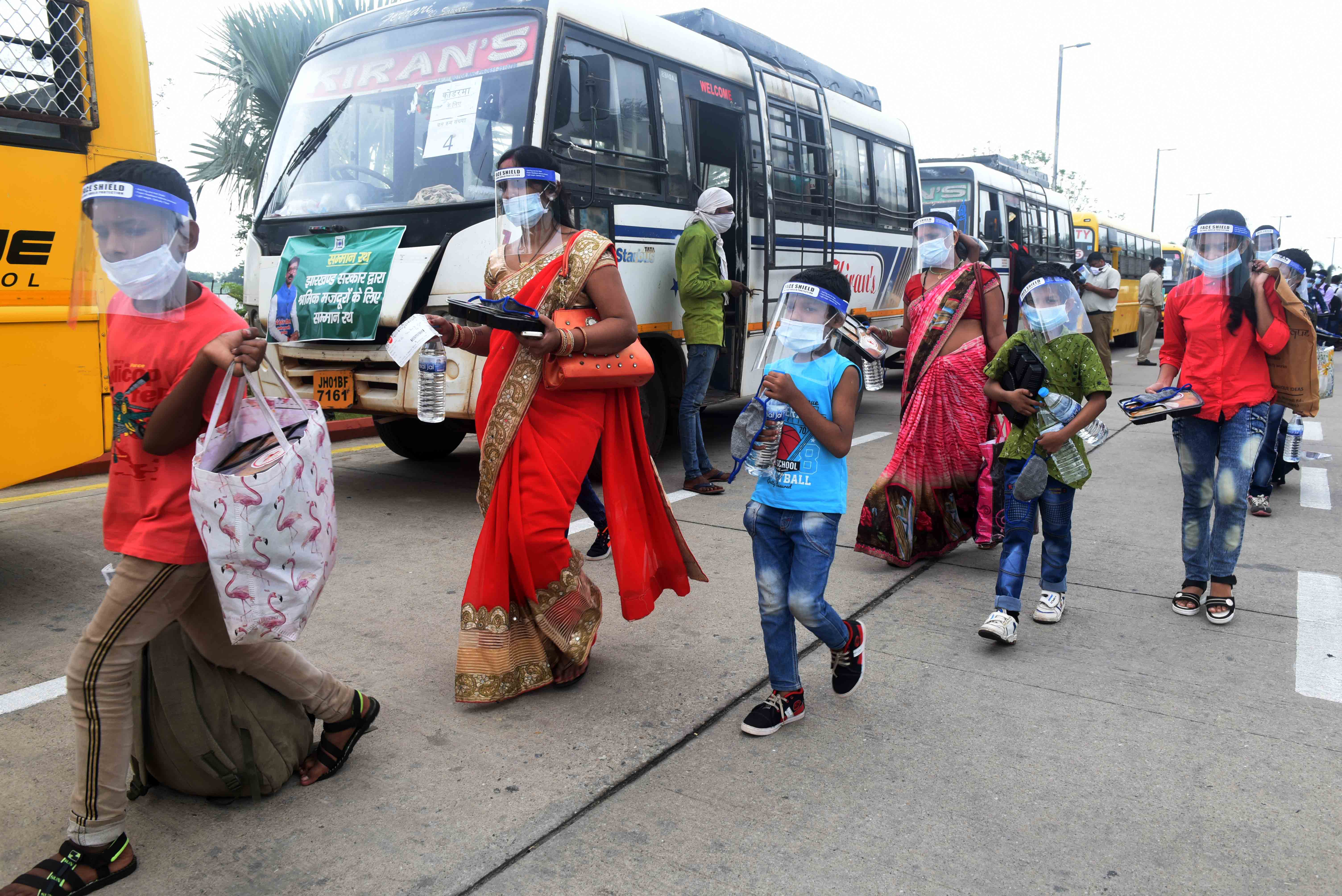 Migrants board buses to go back to their respective home districts, in Ranchi, on Thursday.