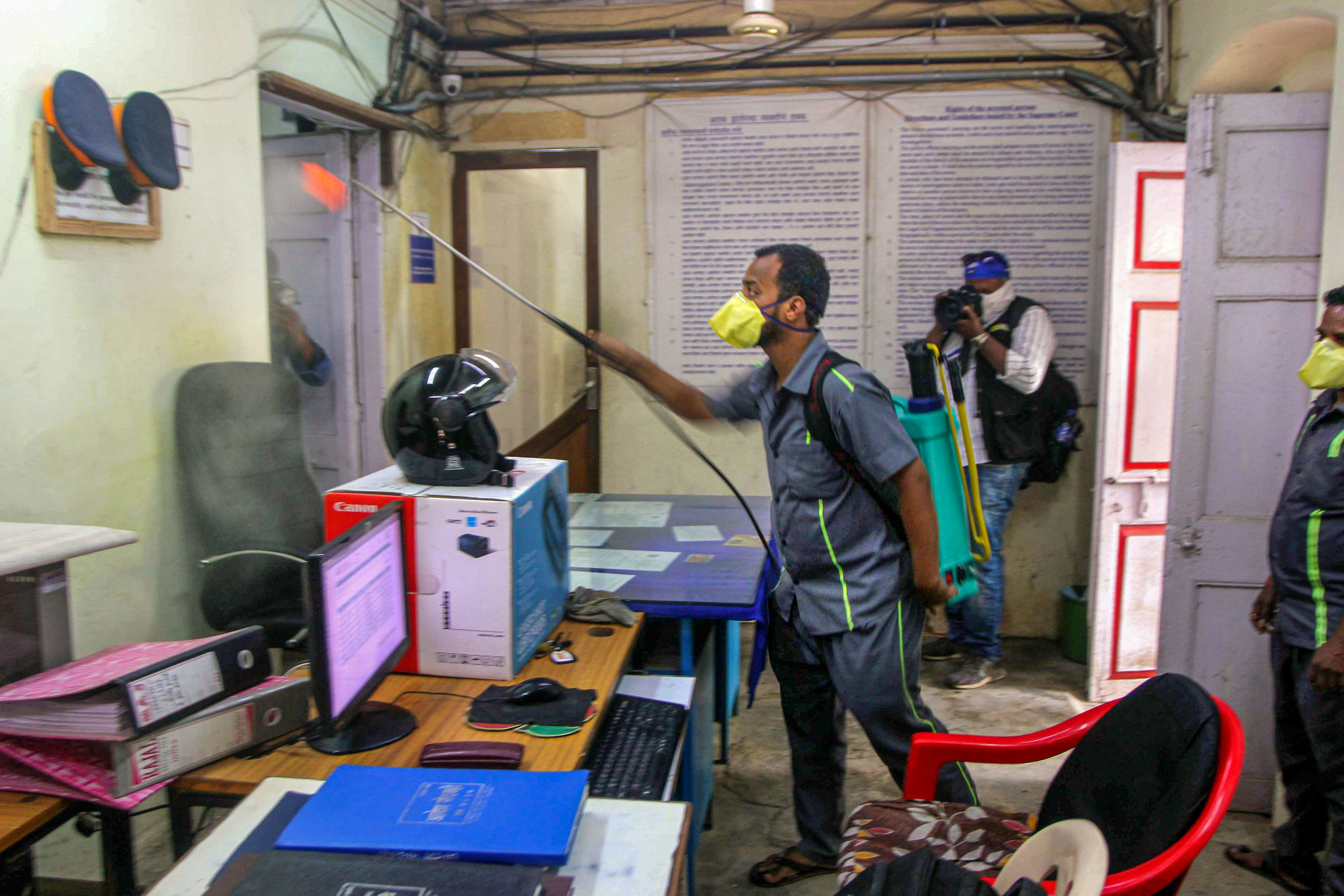 An MCD worker sprays disinfectant inside Gorai Police Station during a nationwide lockdown, imposed in the wake of coronavirus pandemic in Mumbai, Saturday, March 28, 2020