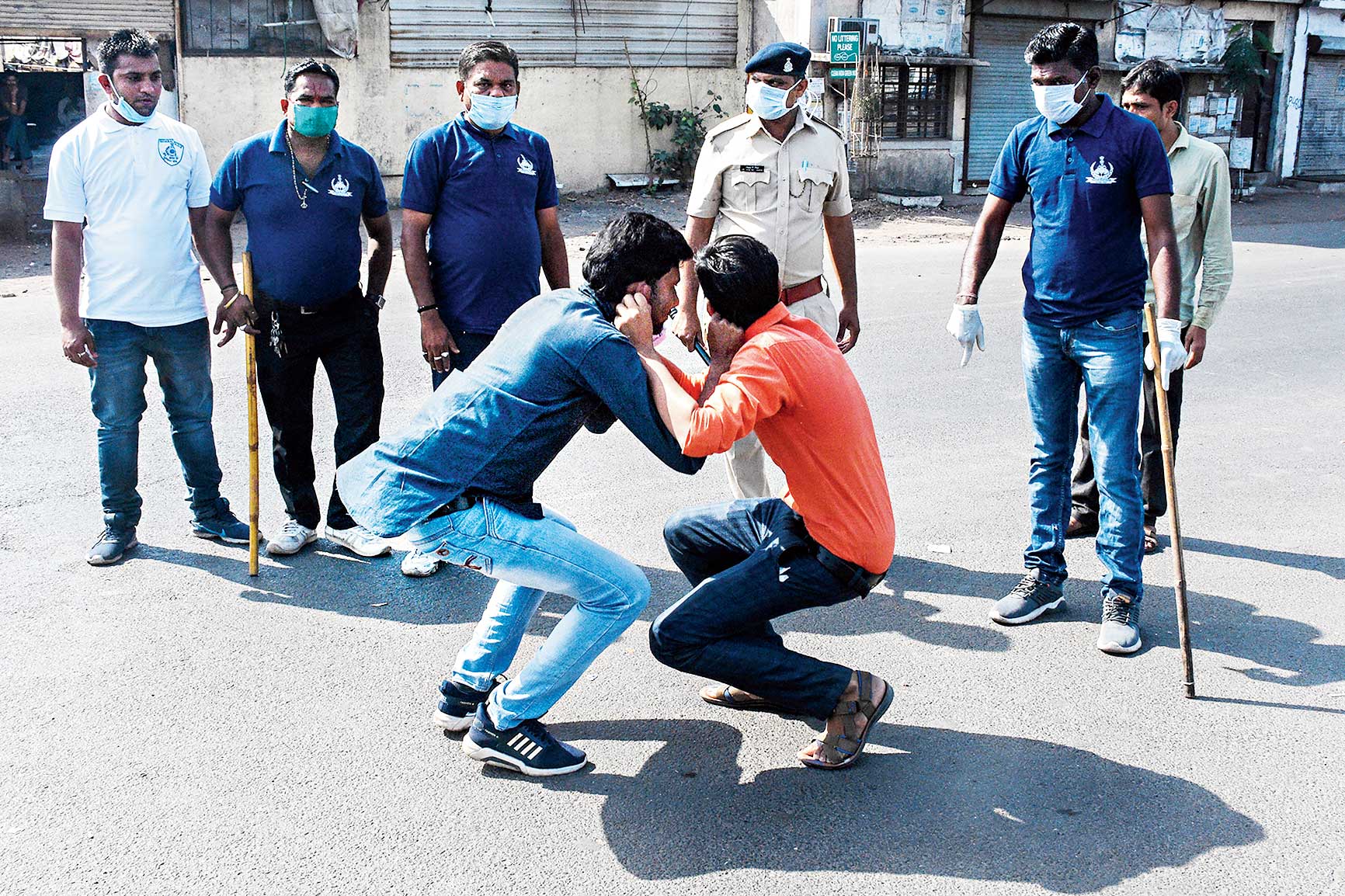 In Surat, lockdown violators are made to hold each other's ears while doing sit-ups.