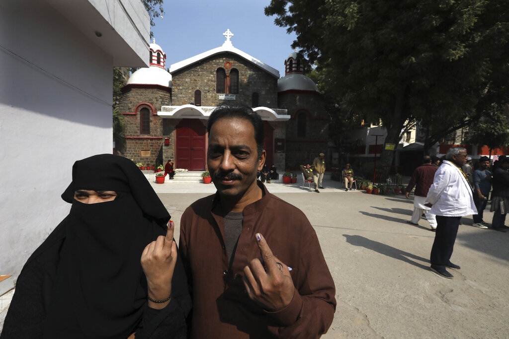 A Muslim couple displays the indelible mark on their finger after casting their vote at a polling station inside a Church complex in New Delhi, on Saturday