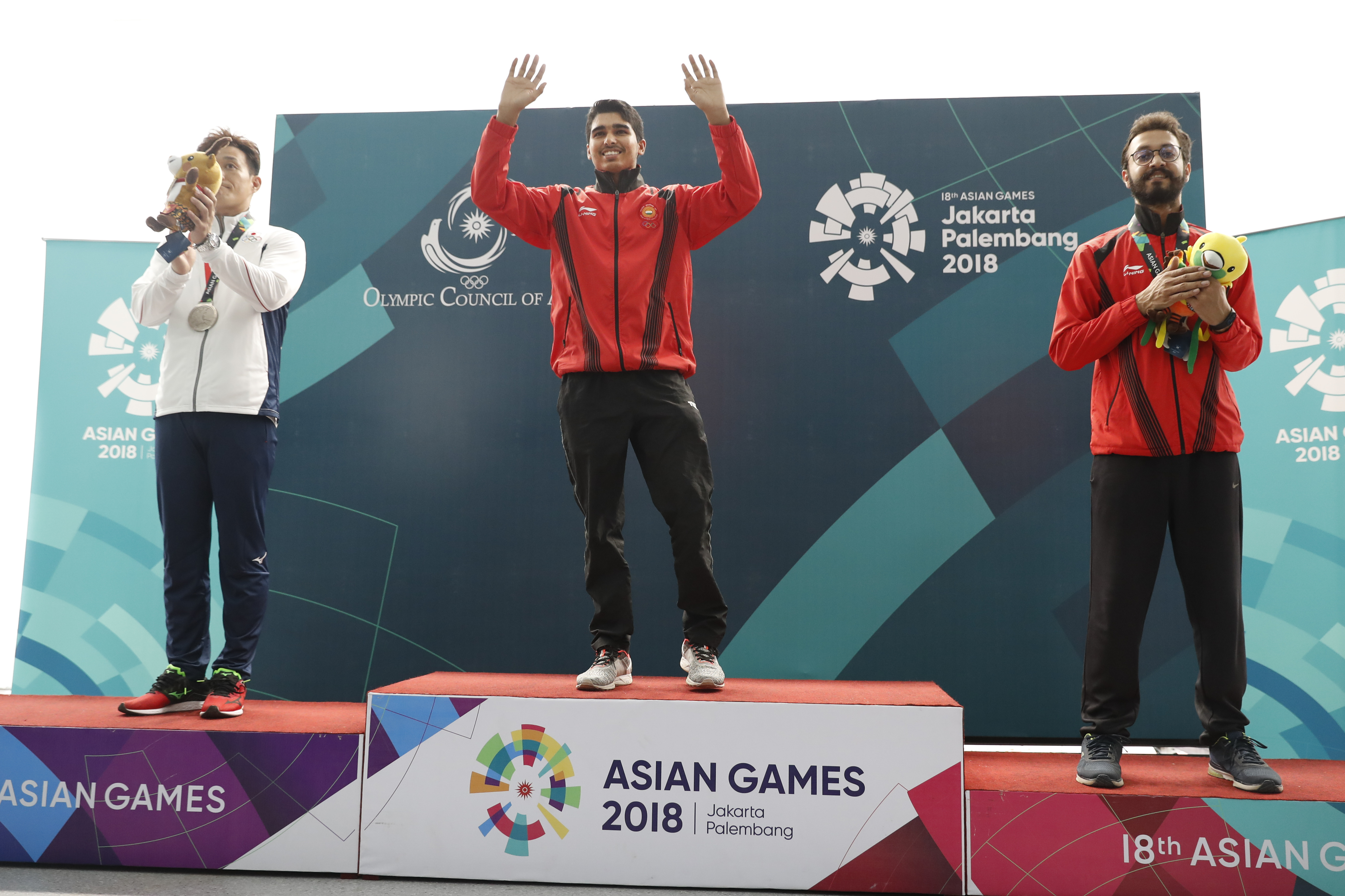 Saurabh Chaudhary flanked by silver medalist Tomoyuki Matsuda (left) and bronze medalist Abhishek Verma on the podium.