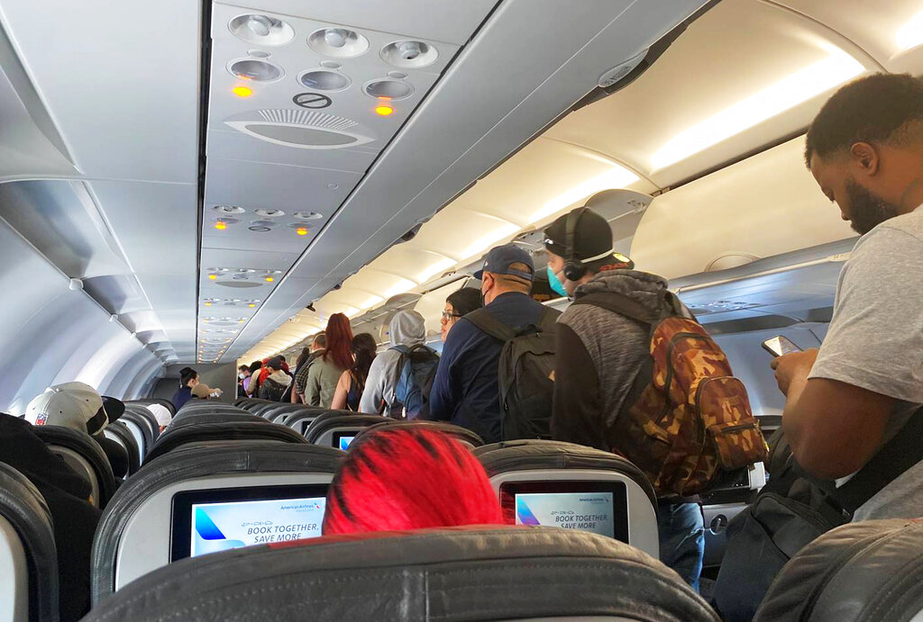In this Monday, April 27, 2020, photo provided by Vince Warburton, passengers get off an American Airlines flight airplane after they landed at Los Angeles International Airport.