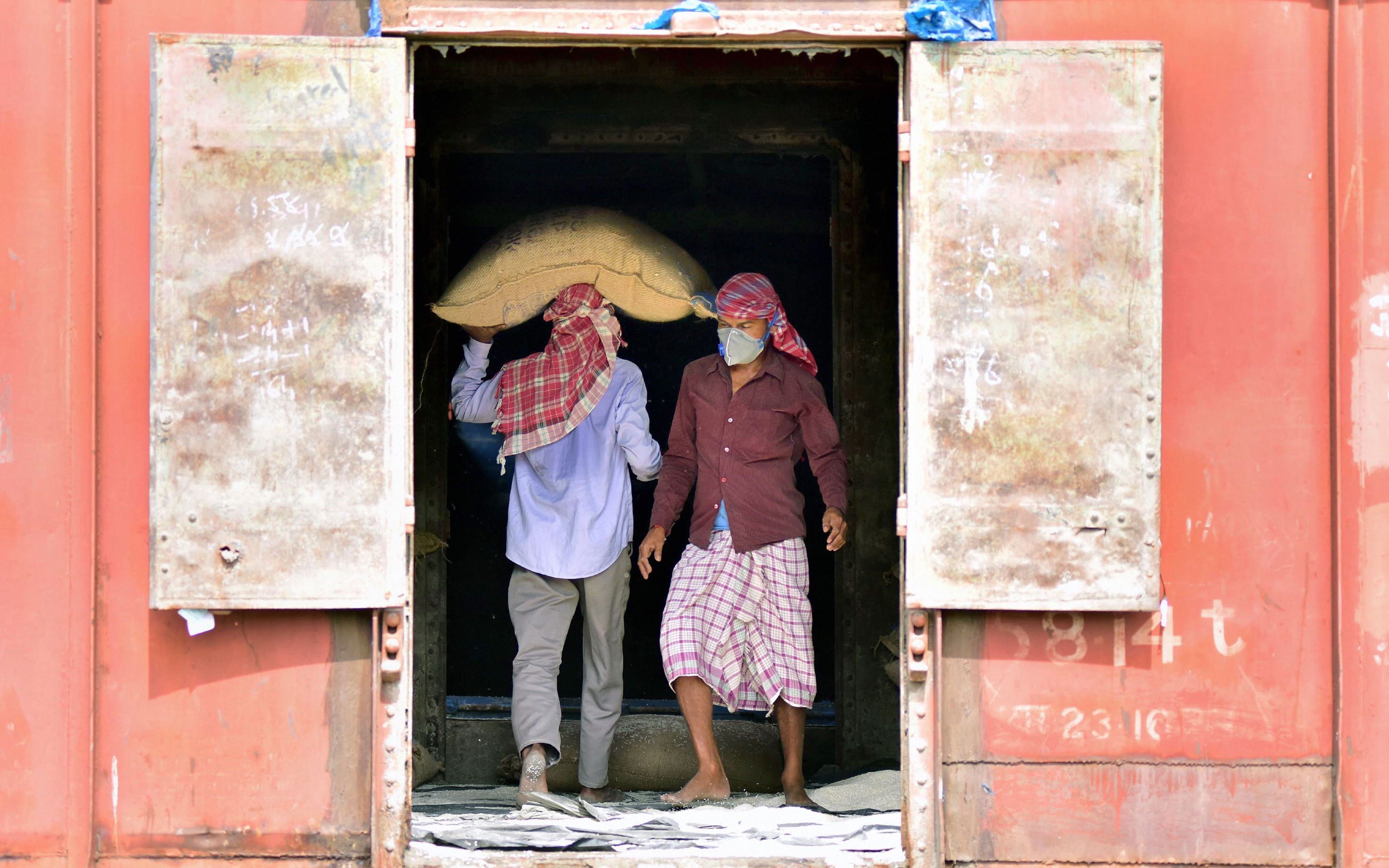 Workers transfer essential items from a goods train to trucks for transportation to various parts of the state during the nationwide lockdown to curb the spread of coronavirus, in Nagaon, Friday, April 17, 2020.