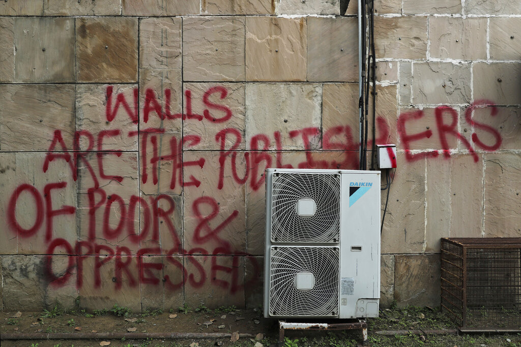 Graffiti in Jamia Millia Islamia that reads "Walls are the publishers of poor and oppressed," spray-painted in the university