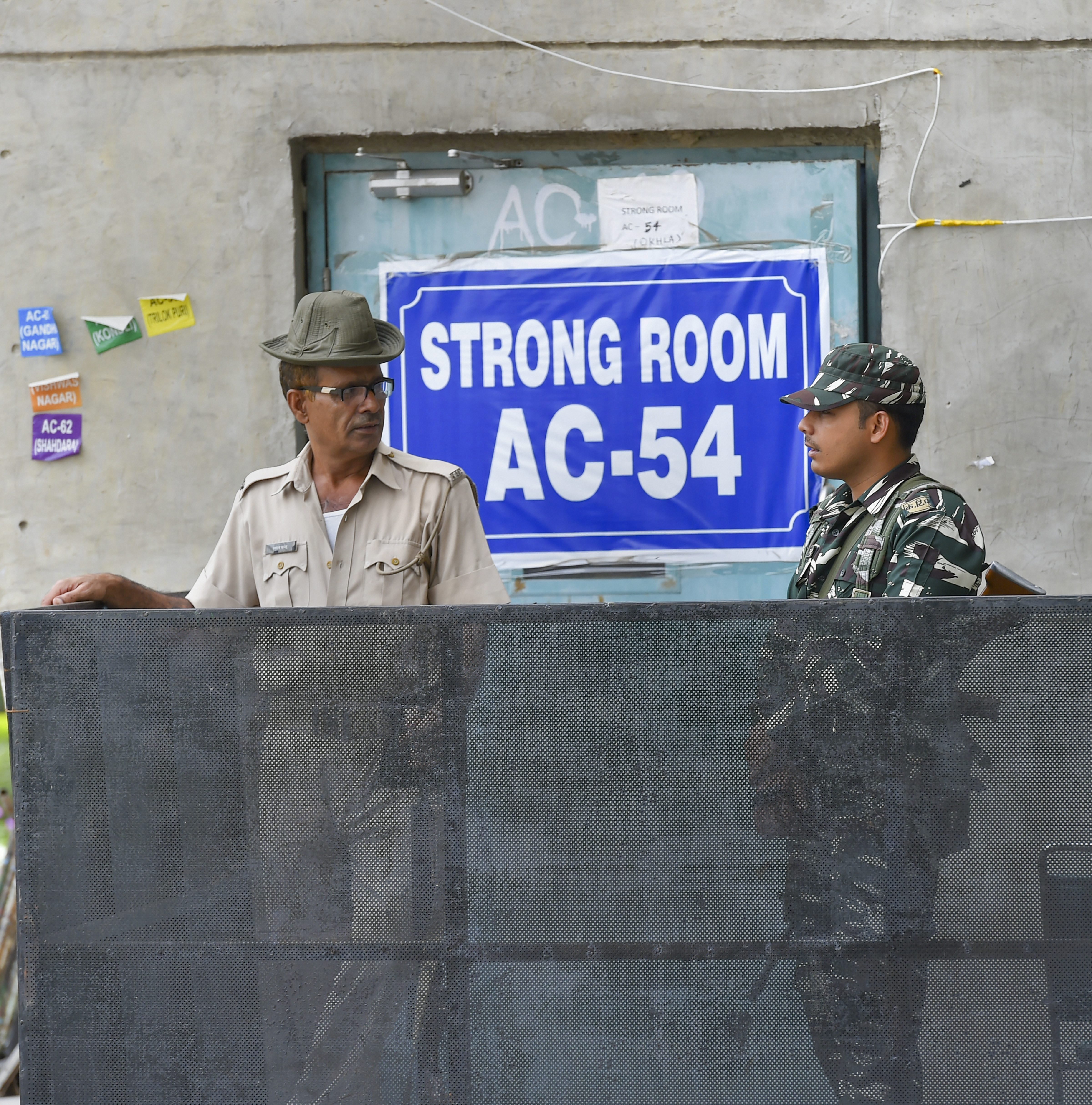 Security personnel stand guard outside a strongroom, where Electronic Voting Machiness are kept after the last phase of Lok Sabha polls at Akshardham in New Delhi on May 22.
