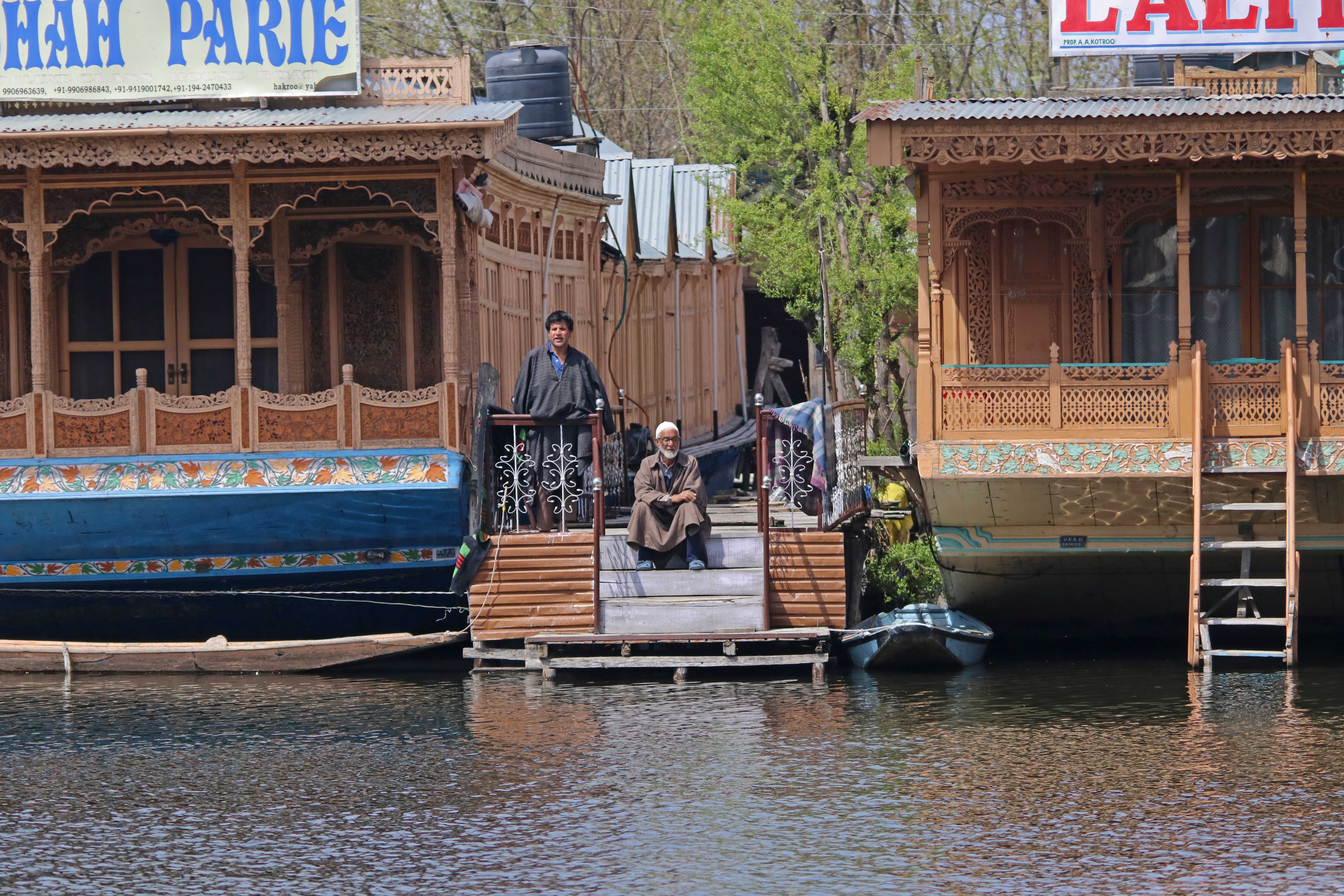 EMPTY NEST:  An elderly man sits at the entrance of a houseboat in Dal Lake, Srinagar.