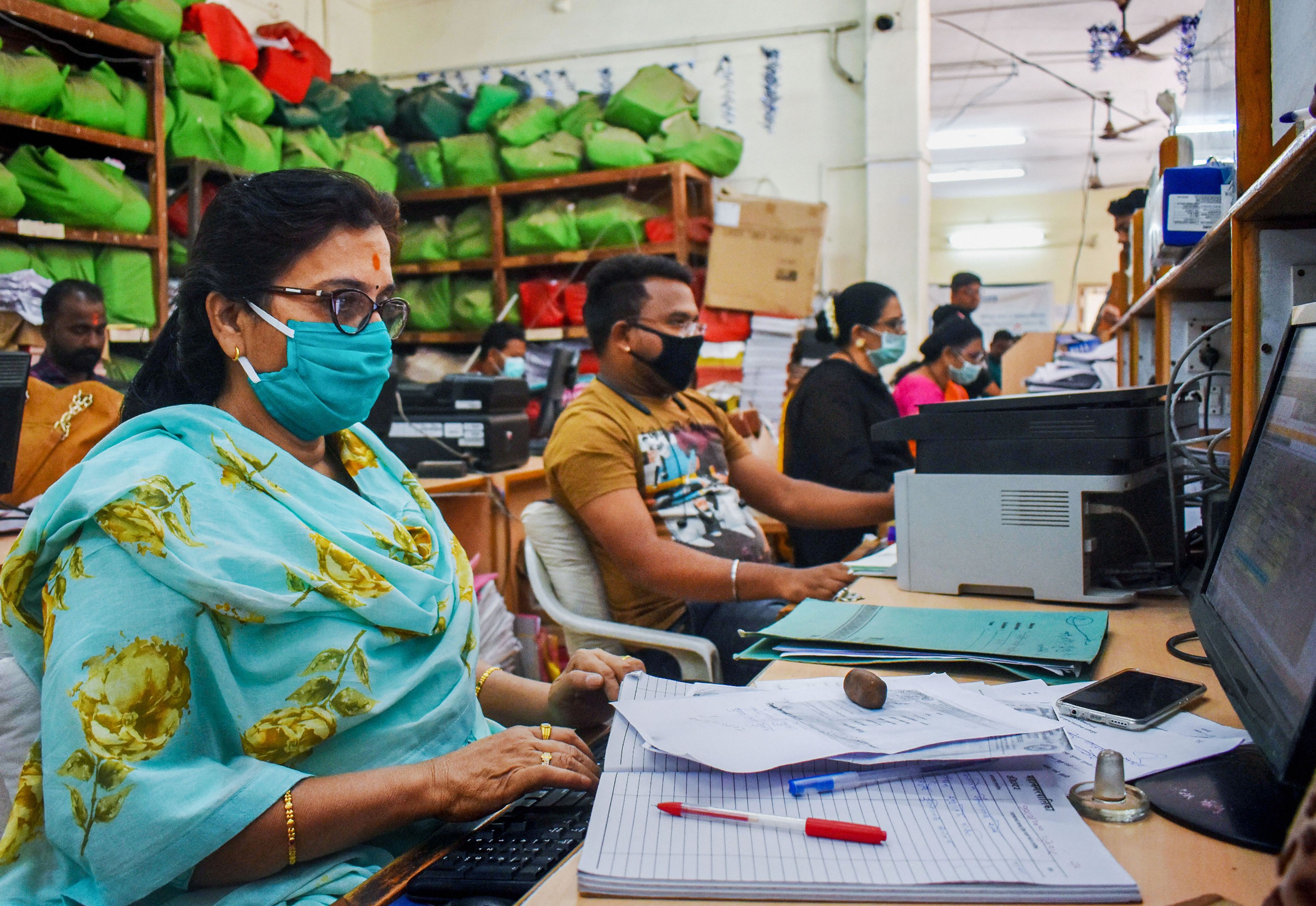 Municipal Corporation workers wear protective masks amid concerns over the spread of coronavirus, at their office in Solapur, Maharashtra, Thursday, March 12, 2020.