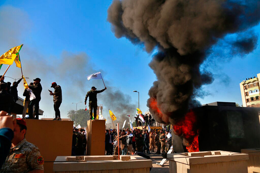Protesters set fires in front of the US embassy compound, in Baghdad, Iraq, on December 31, 2019.