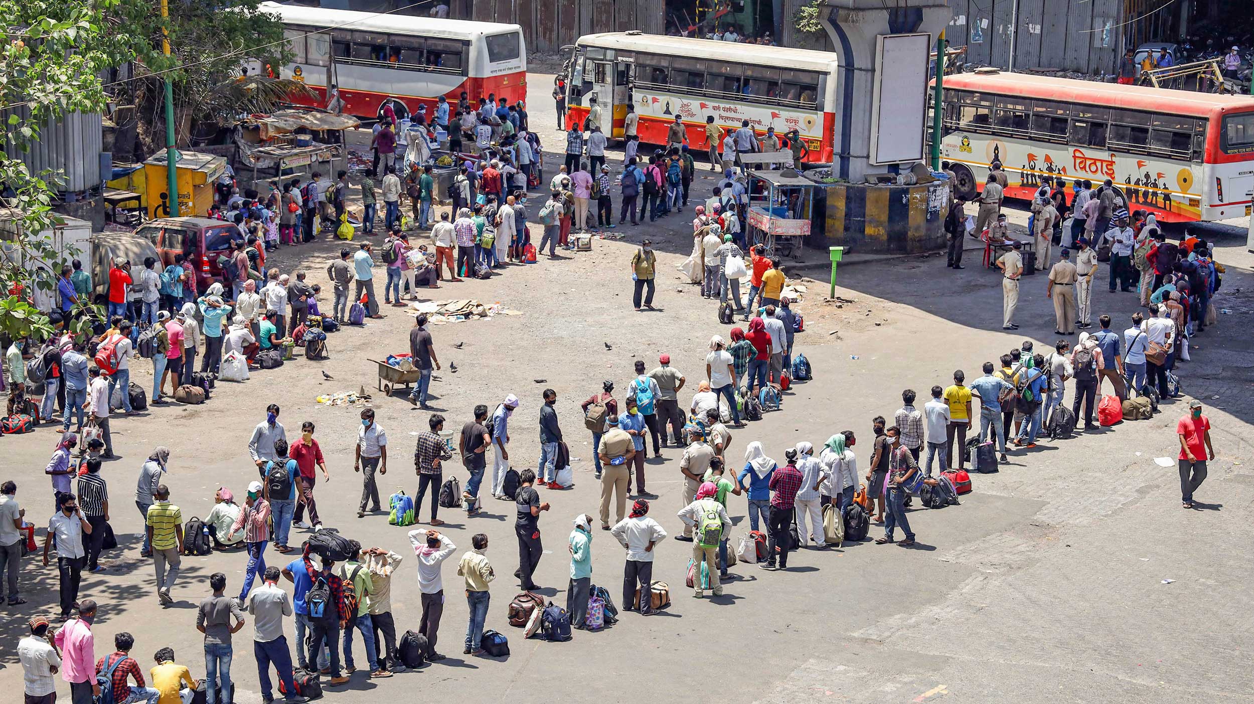 Migrants wait in long queues to board special buses amid the nationwide lockdown in Thane on Tuesday.
