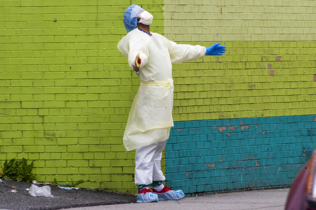 A medic of the Elmhurst Hospital Center medical team reacts after stepping outside of the emergency room, Saturday, April 4, 2020, in the Queens borough of New York.