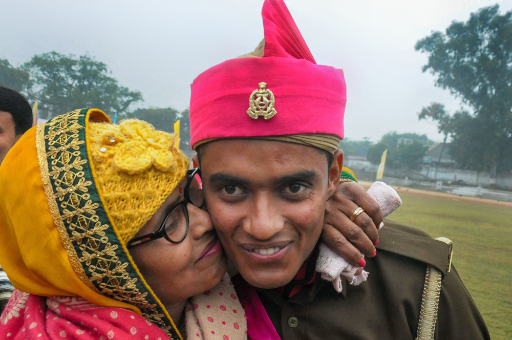A constable of the provincial armed constabulary is greeted by a family member after his passing-out parade at the Police Training College in Moradabad on December 16