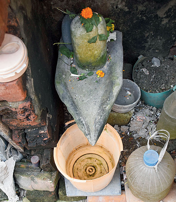 A bucket accumulating water under a Shiva linga