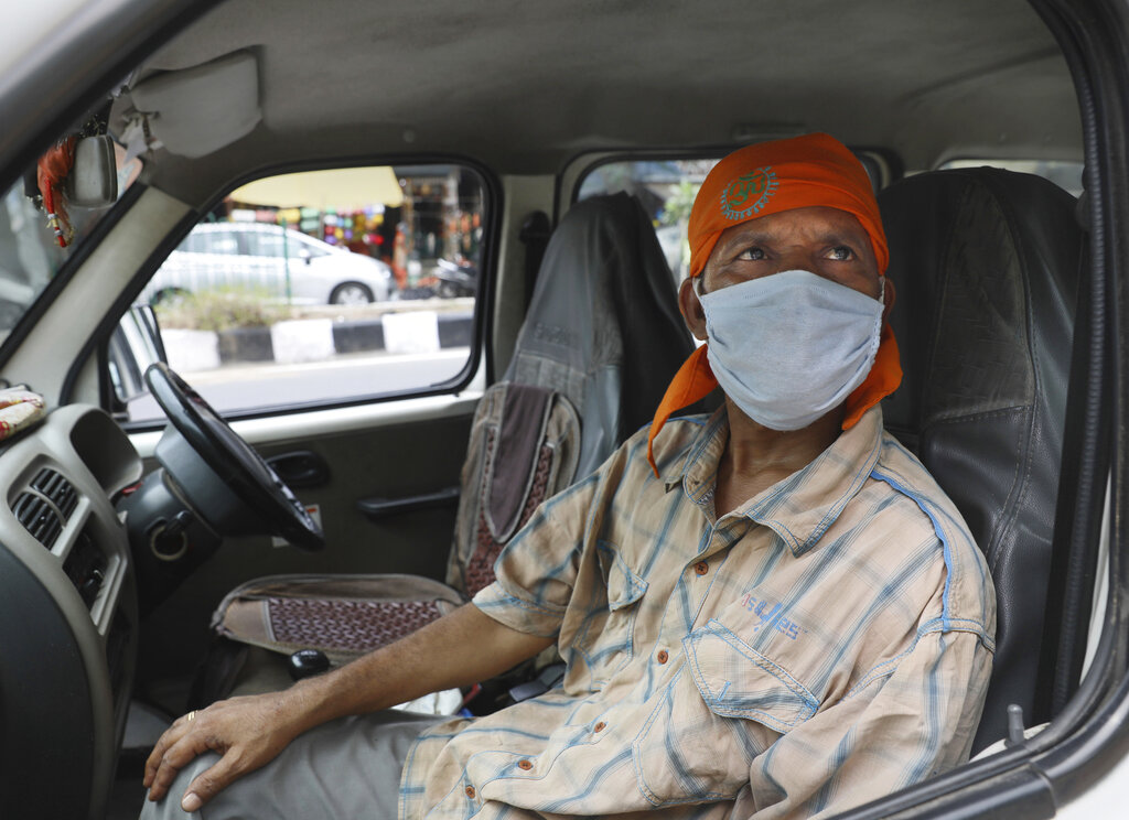 Driver Gangaram, 48, who lost his job and business because of the coronavirus lockdown, sits in his vehicle in New Delhi, Thursday, June 4, 2020. Gangaram used to pick and drop schoolchildren from a New Delhi neighborhood. The job assured him of slim financial security. This is the harsh truth facing workers laid off around the world, from software companies in Israel to restaurants in Thailand and car factories in France, whose livelihoods fell victim to a virus-driven recession that's accelerating decline in struggling industries and upheaval across the global workforce.