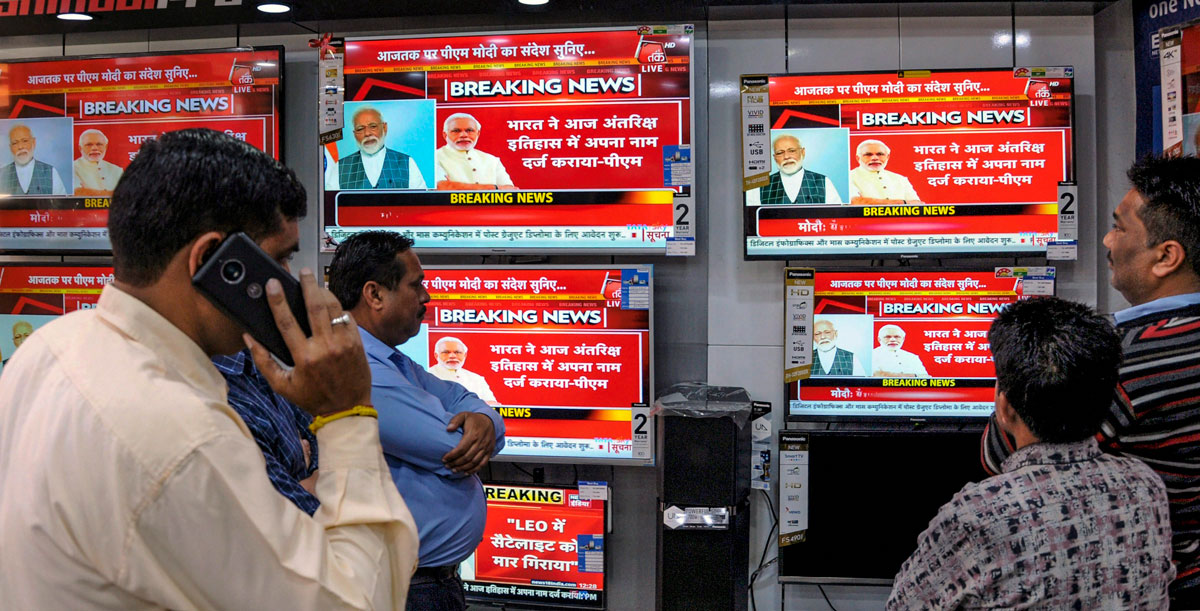 People watch the live telecast of Prime Minister Narendra Modi's address to the nation, on TV screens, in Amritsar, Wednesday, March 27, 2019.