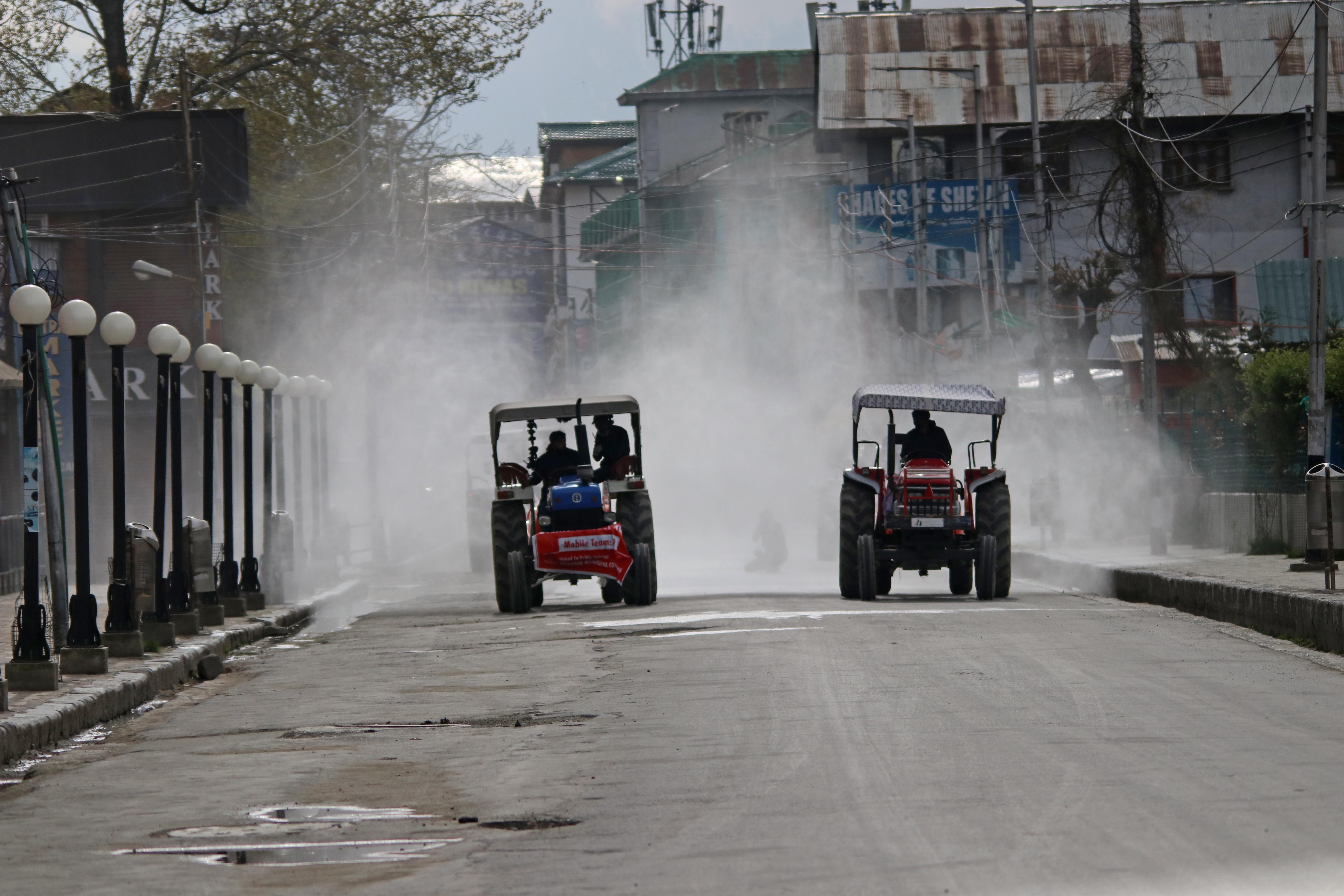 STAY SAFE: Municipal workers spray disinfectants in Lalchowk, Srinagar.
