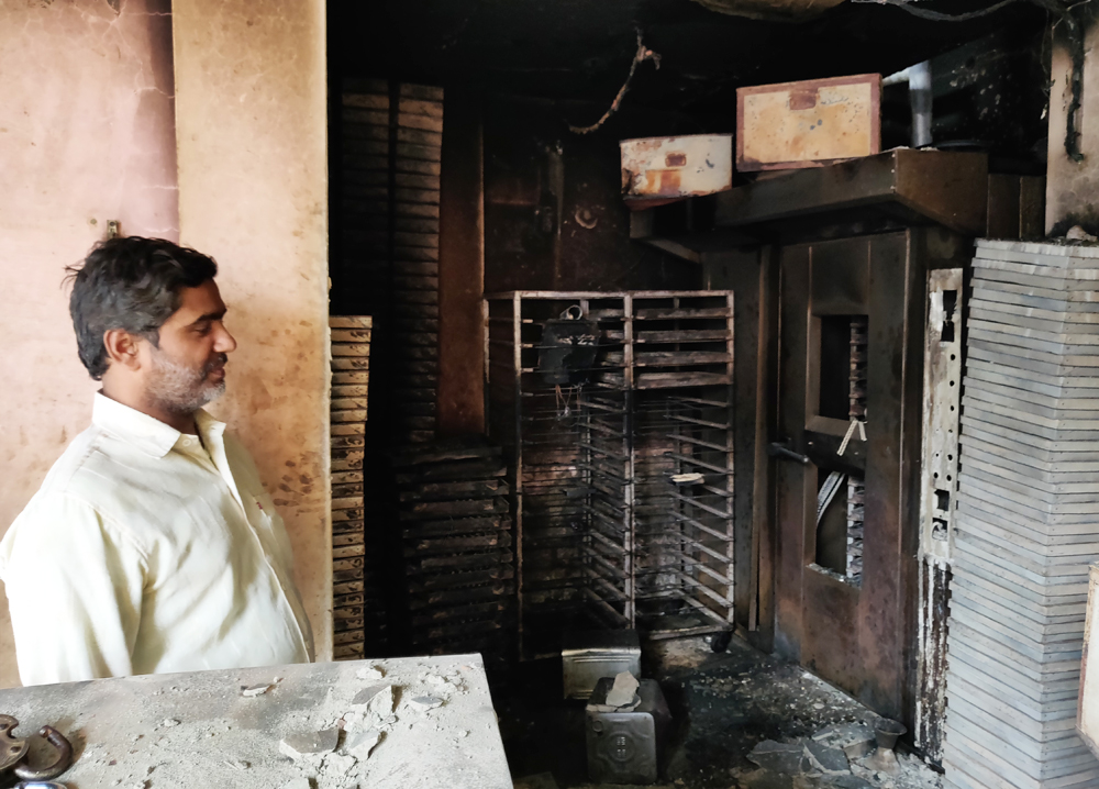 Mohd Asif looks at his bakery gutted in a targeted violence.